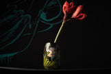 Red flower in a glass vase with a blurred background