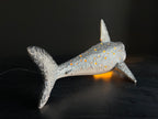 Ceramic shark figurine with a textured pattern on a dark background