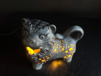 Decorative lion-shaped lantern with glowing interior on a dark background