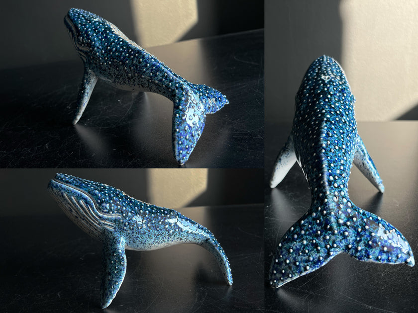 Collage of a blue whale figurine with sparkling details on a dark surface.