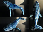 Collage of a blue whale figurine with rhinestone embellishments on a dark surface.