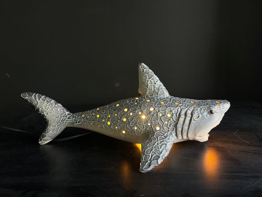 Shark-shaped night light with glowing interior on a dark background