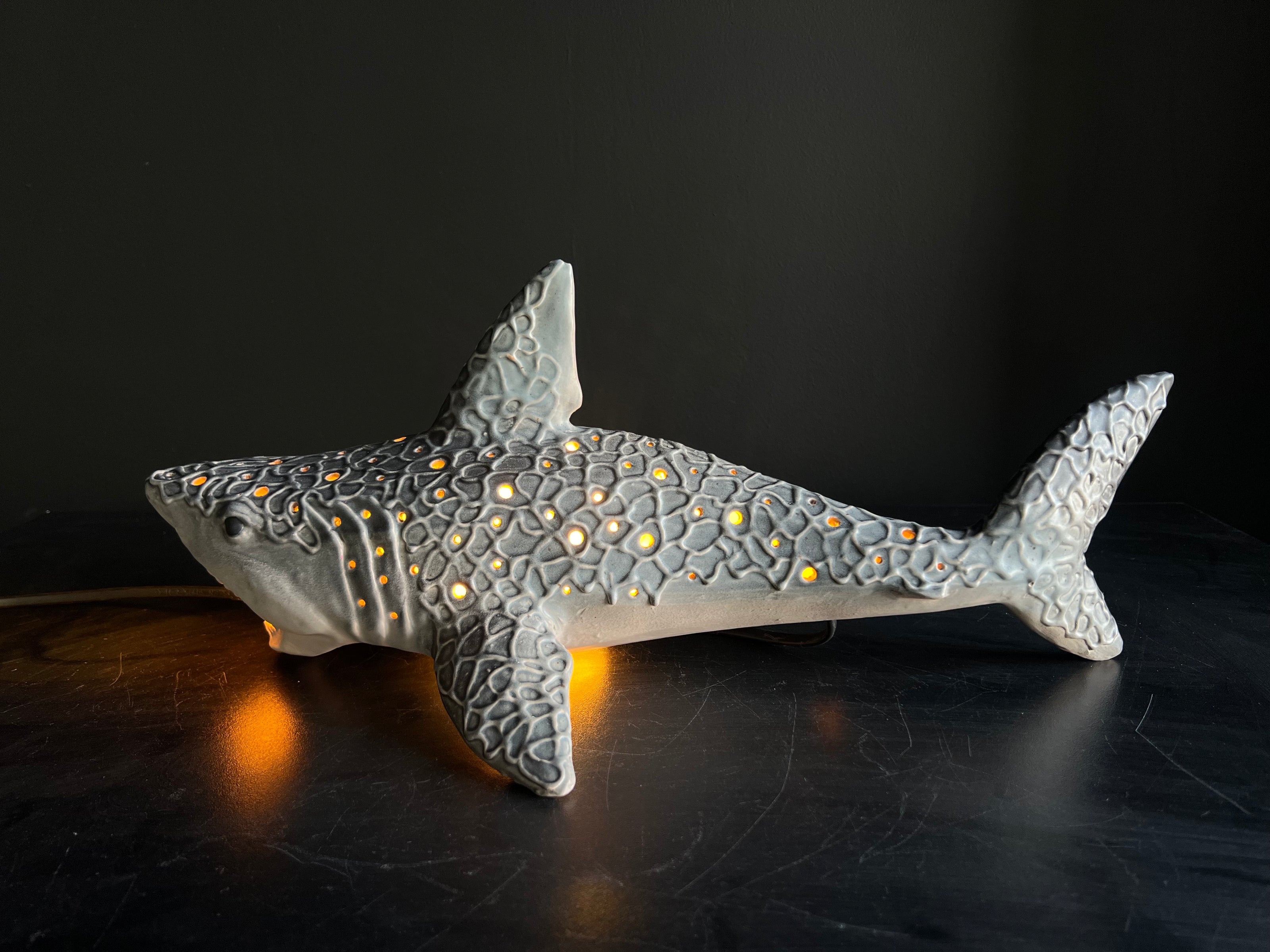 Decorative shark figurine with embedded lights on a dark surface