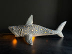Decorative shark figurine with embedded lights on a dark surface
