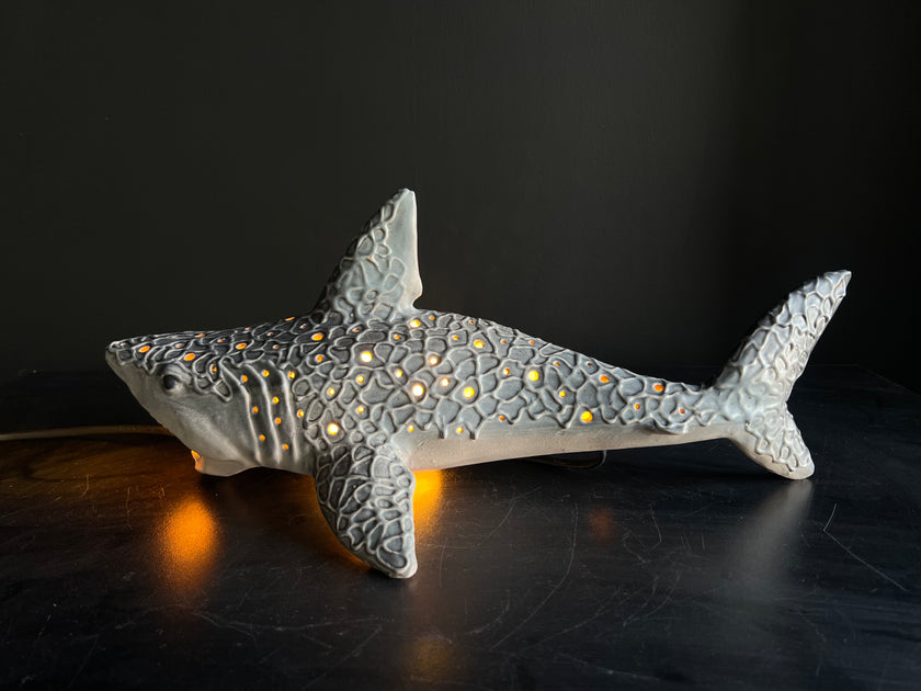 Decorative shark figurine with embedded lights on a dark surface