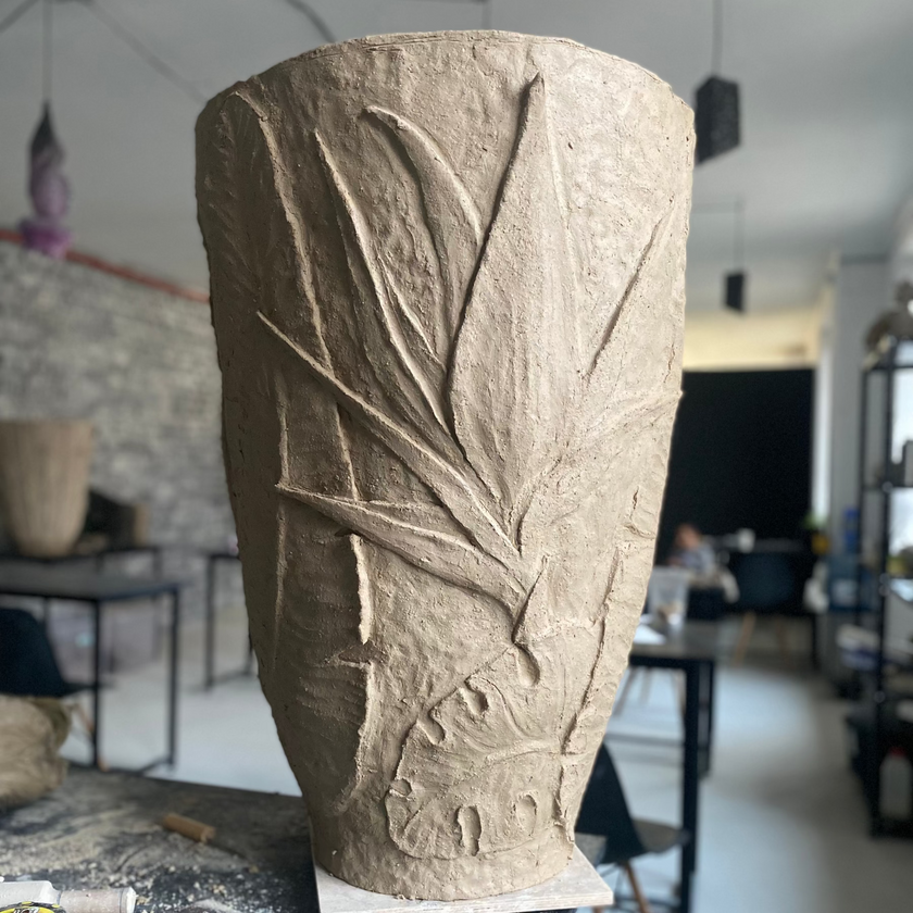 Carved stone vase on a workbench in a workshop setting