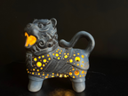 Ceramic lion-shaped lantern with glowing interior on a black background