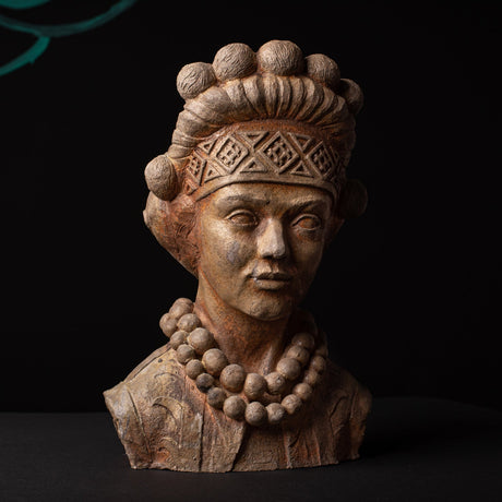Ceramic bust of a figure with intricate headpiece and necklace on a dark background