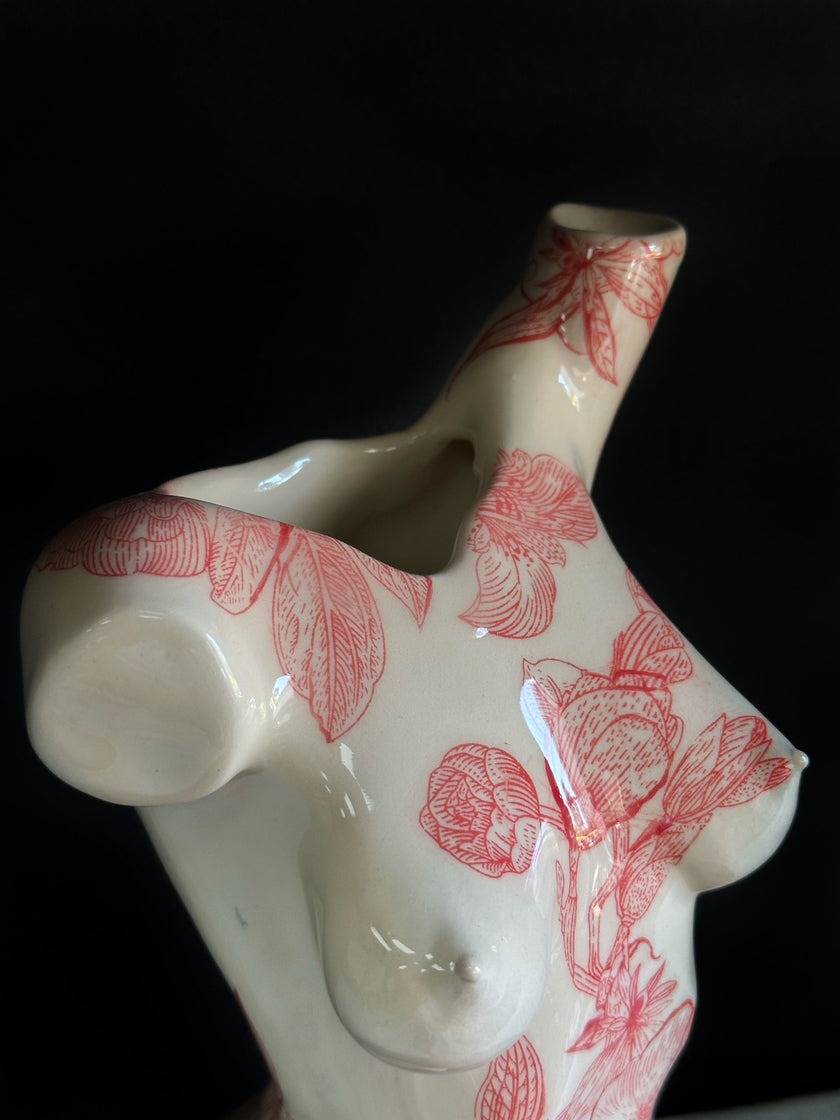 Ceramic vase with red floral pattern on a black background