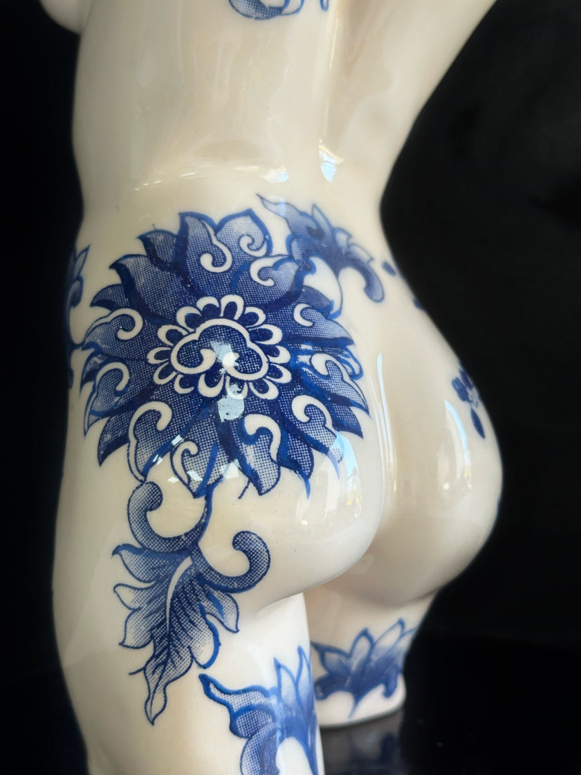 Ceramic figurine with blue floral patterns on a black background