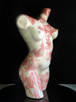 Ceramic sculpture of a female torso with red floral patterns on a black background